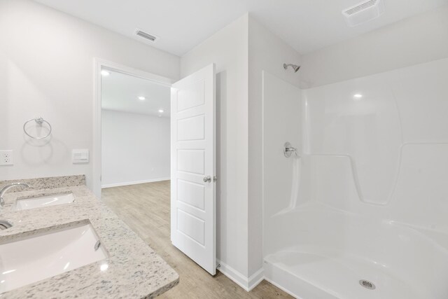 bathroom with vanity, hardwood / wood-style flooring, and walk in shower