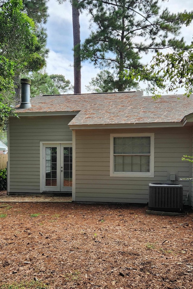 back of property with central AC unit and french doors