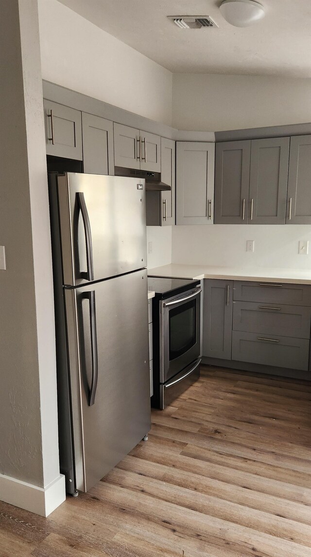 kitchen featuring stainless steel appliances, gray cabinetry, and light hardwood / wood-style flooring