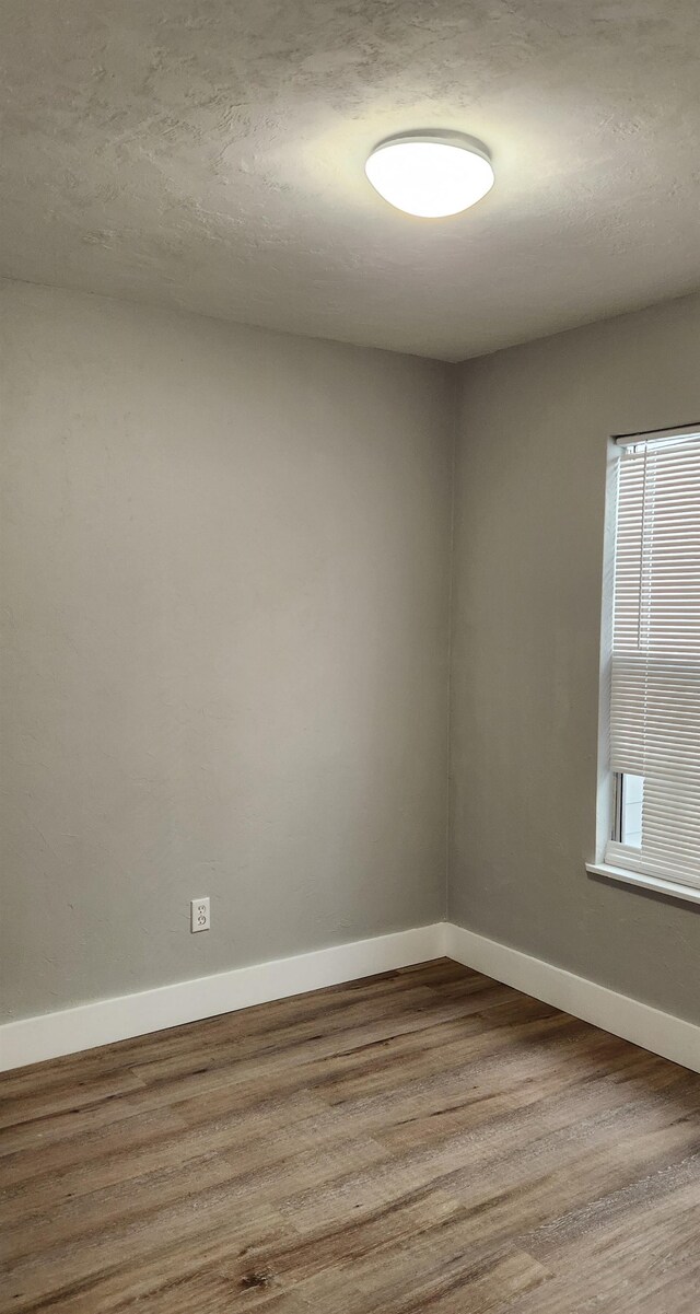 unfurnished room with hardwood / wood-style floors