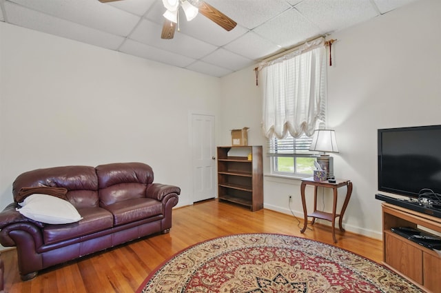 1118 W Green St, Perry, FL 32347 - living room featuring a drop ceiling, wood finished floors, ceiling fan, and baseboards