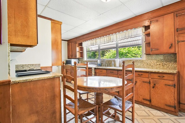 1118 W Green St, Perry, FL 32347 - kitchen featuring open shelves, a sink, brown cabinets, and a paneled ceiling