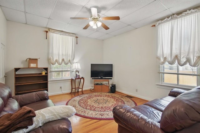 1118 W Green St, Perry, FL 32347 - living area featuring a drop ceiling, plenty of natural light, a ceiling fan, wood finished floors, and baseboards