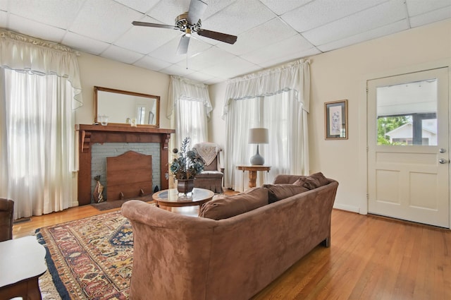 1118 W Green St, Perry, FL 32347 - living area featuring a ceiling fan, a drop ceiling, wood finished floors, and a brick fireplace