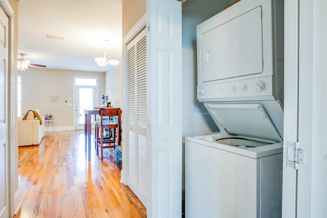 415 Saint Francis St Unit 133, Tallahassee, FL 32301 - washroom featuring estacked washer and dryer, light wood-style floors, baseboards, ceiling fan, and a chandelier