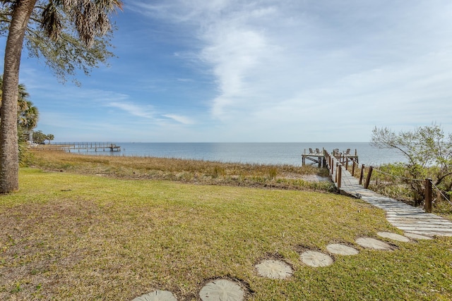 view of yard with a water view and a dock