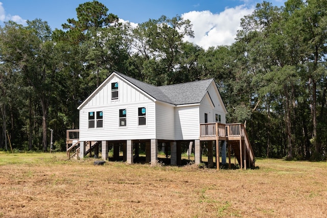 rear view of house featuring a lawn and a deck