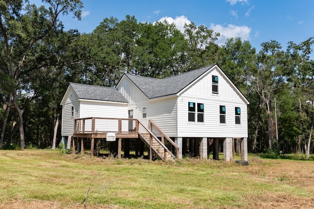 back of property with a deck and a lawn