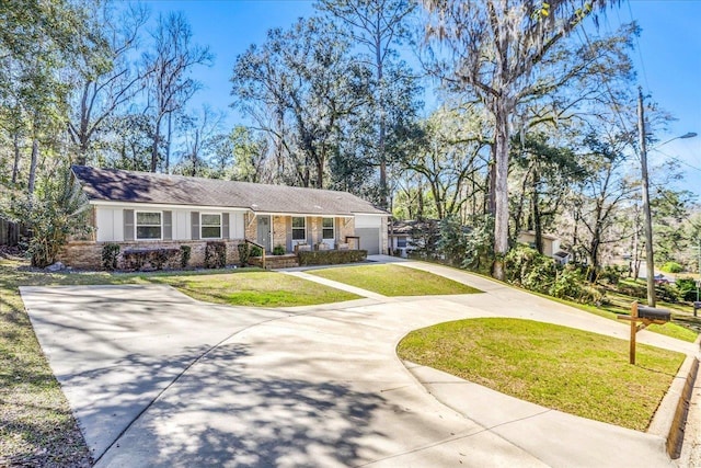 view of front facade featuring stucco siding, concrete driveway, and a front lawn