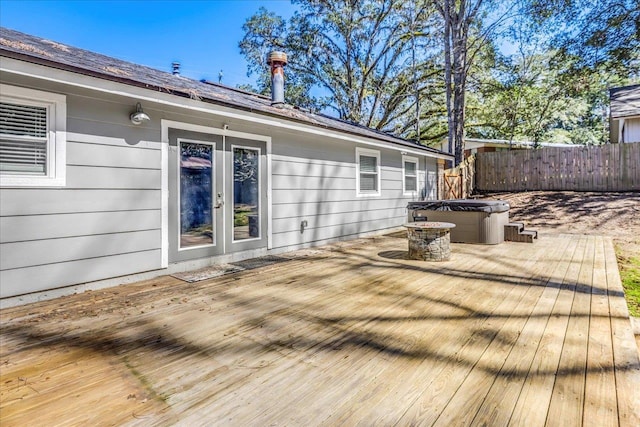 deck featuring french doors, fence, and a hot tub