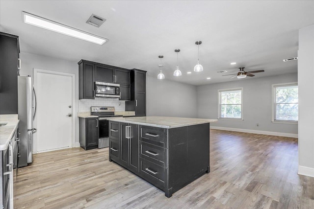 kitchen with visible vents, a ceiling fan, backsplash, dark cabinetry, and stainless steel appliances