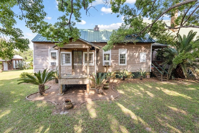 back of house featuring stairway, a yard, metal roof, and cooling unit
