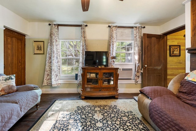 living room featuring a ceiling fan, baseboards, and wood finished floors