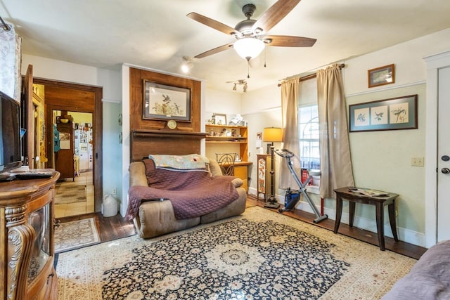 bedroom with baseboards, a ceiling fan, and wood finished floors