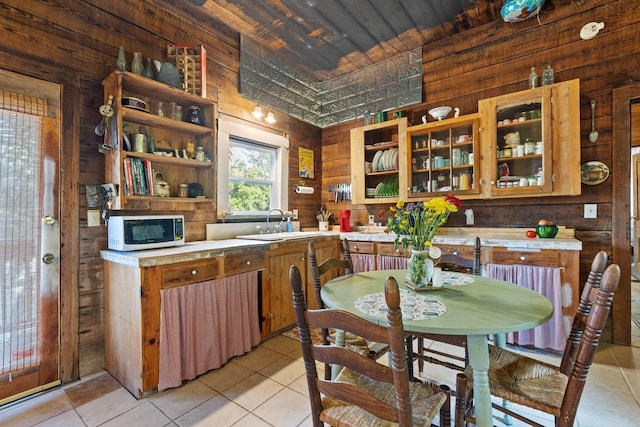 kitchen featuring wooden walls, open shelves, light tile patterned floors, and white microwave