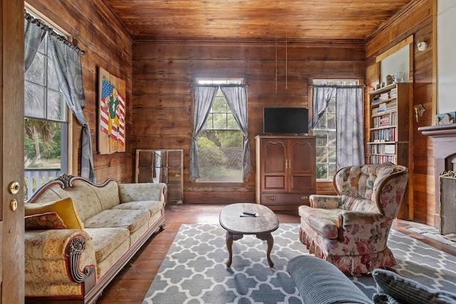 living area with wood-type flooring, wood walls, wood ceiling, and a fireplace