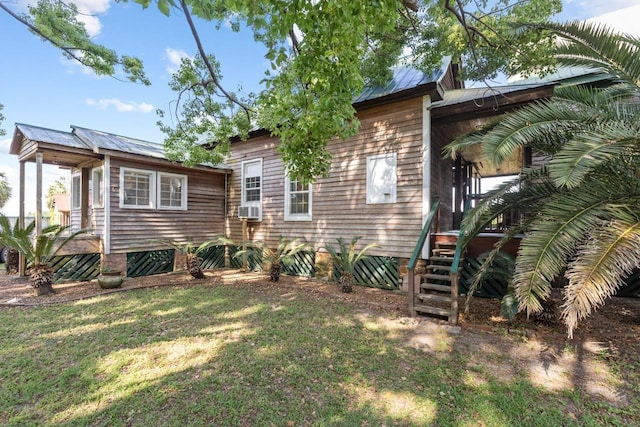back of house with a yard, cooling unit, and metal roof