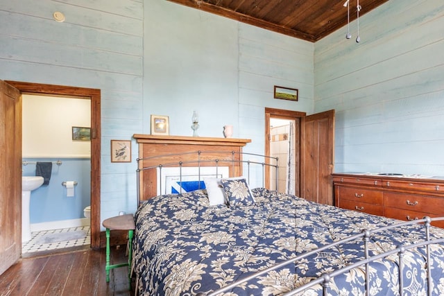 bedroom featuring baseboards, wood walls, dark wood-style floors, and wooden ceiling