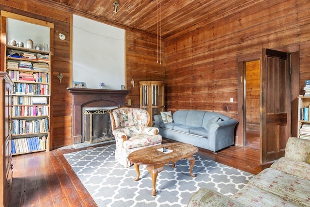 living room featuring wood walls, a fireplace, hardwood / wood-style floors, and wooden ceiling
