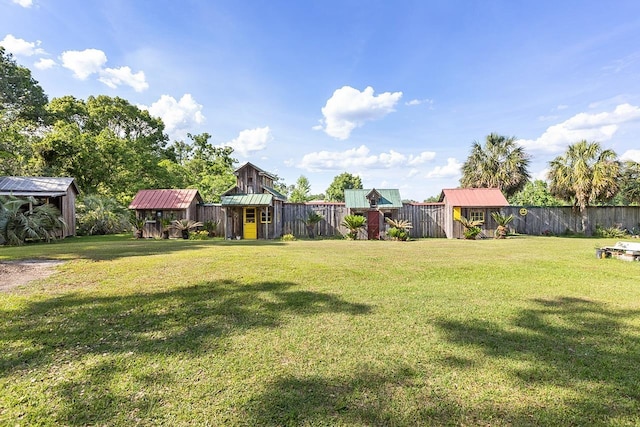 view of yard with fence, an outbuilding, and a shed