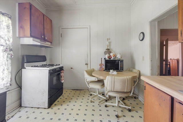 143 Washington Ave, Havana, FL 32333 - kitchen with range with gas cooktop, under cabinet range hood, black microwave, light flooring, and light countertops