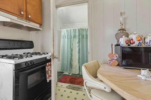 143 Washington Ave, Havana, FL 32333 - kitchen featuring black gas stove, under cabinet range hood, and brown cabinets