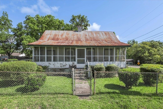 143 Washington Ave, Havana, FL 32333 - view of front of house with a sunroom, a gate, a chimney, metal roof, and stucco siding