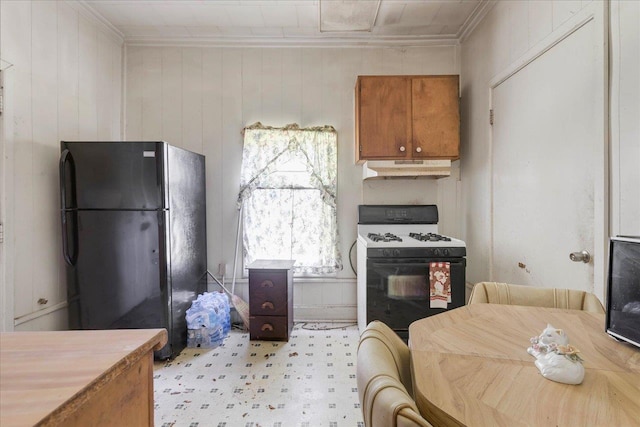 143 Washington Ave, Havana, FL 32333 - kitchen with gas range, freestanding refrigerator, crown molding, brown cabinetry, and under cabinet range hood