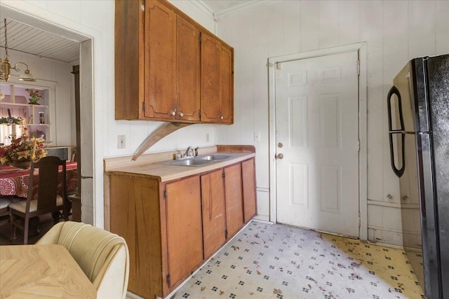 143 Washington Ave, Havana, FL 32333 - kitchen with freestanding refrigerator, a sink, light floors, light countertops, and brown cabinetry