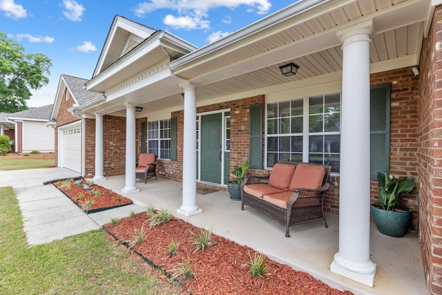 view of patio / terrace featuring a garage, covered porch, and driveway