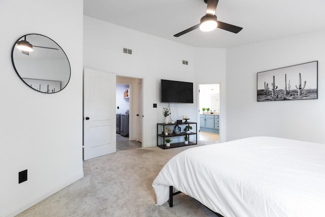 bedroom with visible vents, connected bathroom, washer / clothes dryer, and light carpet