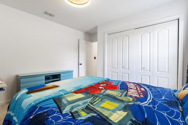 bedroom featuring baseboards, visible vents, carpet, and a closet