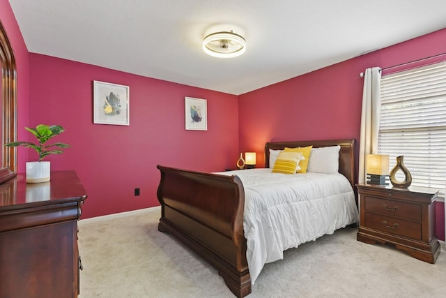 bedroom with baseboards and light carpet