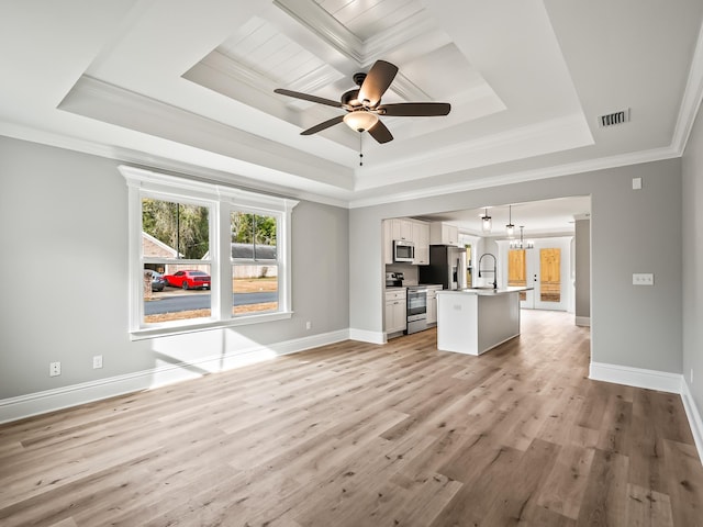 65 Sioux Trl, Crawfordville, FL 32327 - unfurnished living room featuring a tray ceiling, ornamental molding, light wood-type flooring, a ceiling fan, and a sink
