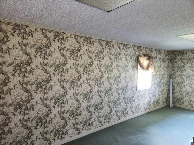 carpeted empty room featuring a textured ceiling