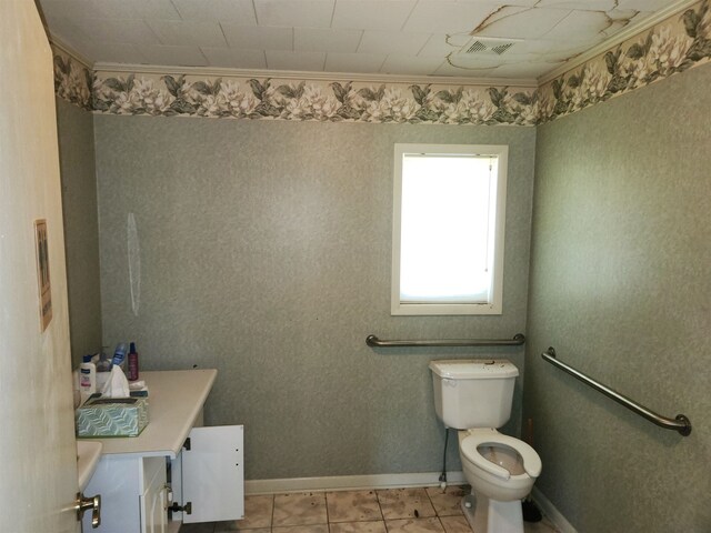 bathroom with tile patterned flooring, vanity, toilet, and crown molding