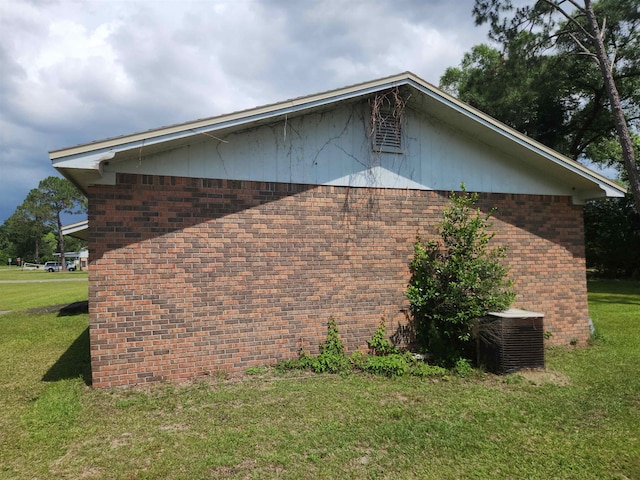 view of side of home with cooling unit and a lawn