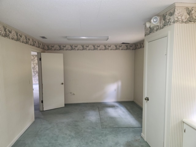 empty room featuring light carpet and a textured ceiling