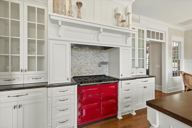 4640 Grove Park Dr, Tallahassee, FL 32311 - kitchen featuring gas stovetop, ornamental molding, dark countertops, dark wood-style flooring, and glass insert cabinets
