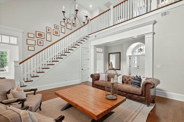 4640 Grove Park Dr, Tallahassee, FL 32311 - living room with a high ceiling, a chandelier, wood finished floors, decorative columns, and stairs