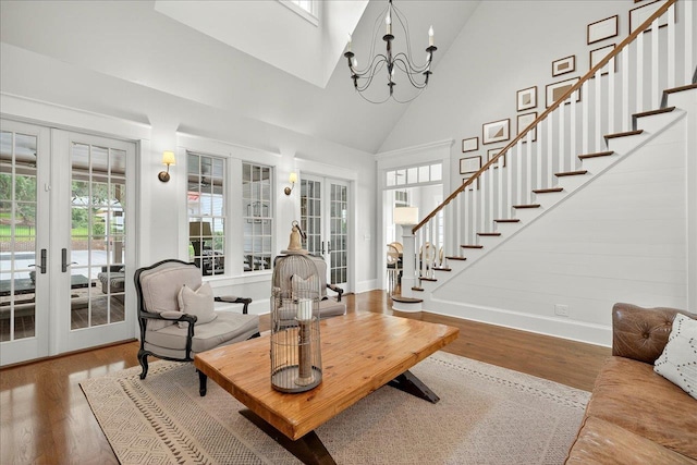 4640 Grove Park Dr, Tallahassee, FL 32311 - living room featuring french doors, high vaulted ceiling, healthy amount of natural light, wood finished floors, and a chandelier