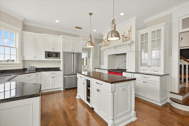 4640 Grove Park Dr, Tallahassee, FL 32311 - kitchen with stainless steel appliances, beverage cooler, healthy amount of natural light, white cabinetry, and ornamental molding