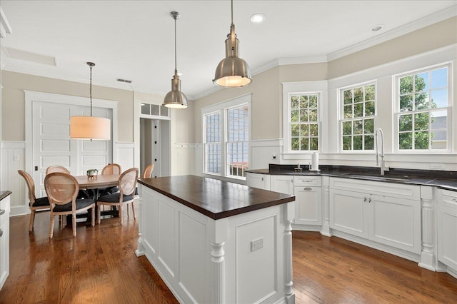 4640 Grove Park Dr, Tallahassee, FL 32311 - kitchen featuring ornamental molding, a decorative wall, wainscoting, dark wood finished floors, and a center island