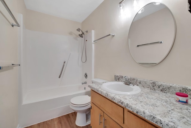 full bathroom featuring vanity, hardwood / wood-style flooring, toilet, and  shower combination