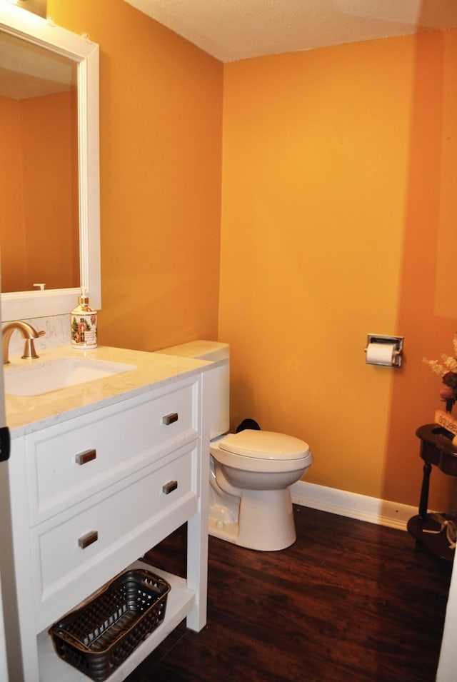 bathroom featuring vanity, hardwood / wood-style floors, and toilet