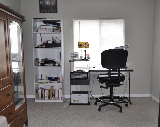 carpeted home office featuring built in shelves