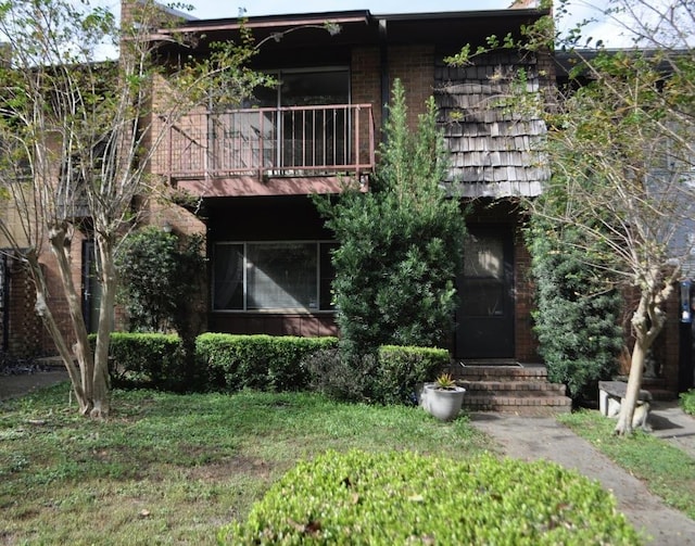 view of front of home featuring a front yard and a balcony