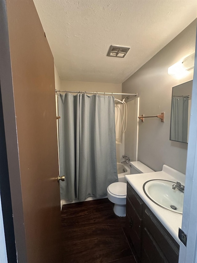 214 Belmont Rd, Tallahassee, FL 32301 - bathroom with wood finished floors, a textured ceiling, shower / tub combo, vanity, and toilet