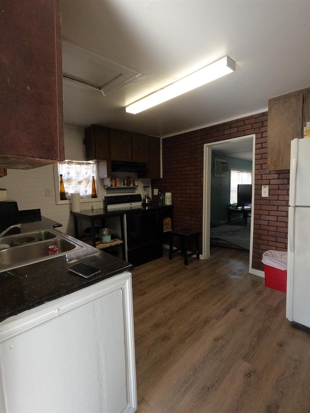 kitchen featuring brick wall, dark hardwood / wood-style floors, sink, white refrigerator, and dark brown cabinetry