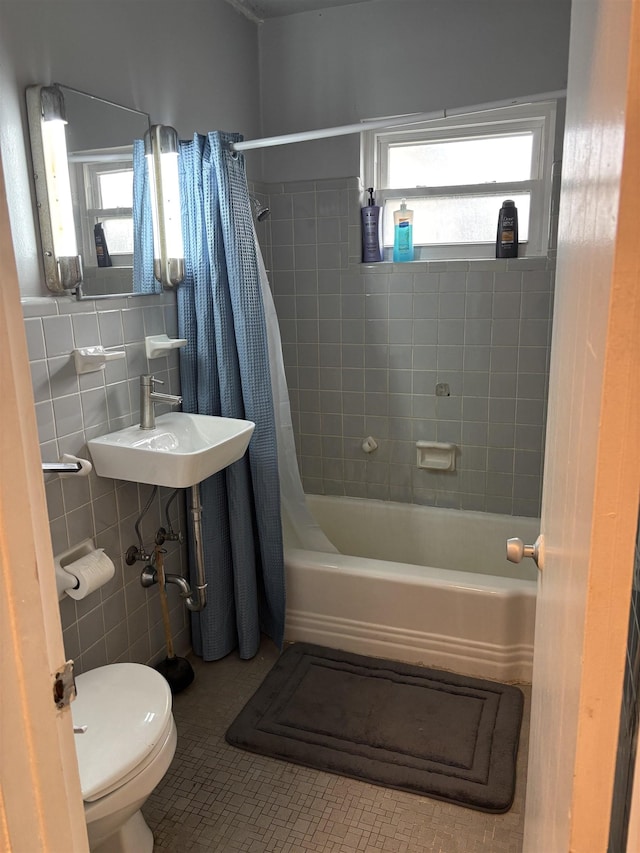 full bathroom with tile patterned floors, a wealth of natural light, sink, and shower / bathtub combination with curtain